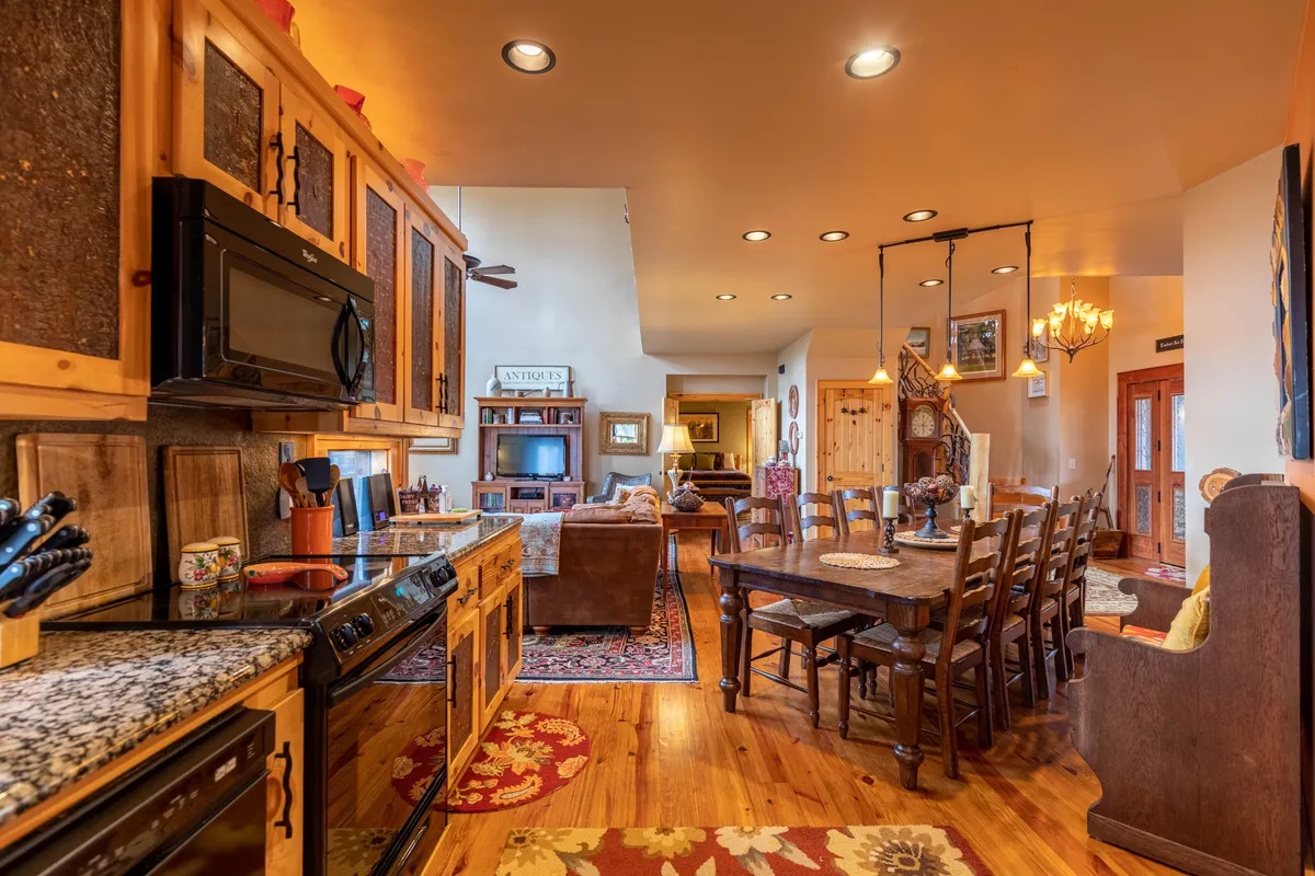 A bright open-plan area blends the kitchen, dining table, and living space, ideal for gathering, socializing, and preparing for the day's escapades. The inviting ambiance hints at shared moments before or after exploring the mountains.